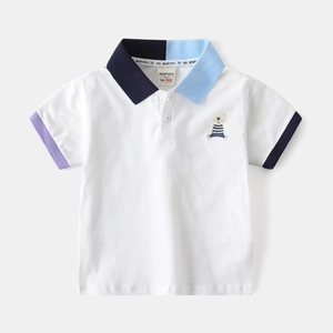 Détail d'un polo enfant avec col contrasté et broderie d'ours mignonne sur coton blanc