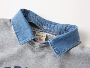 Détail du faux col double couche sur un sweat-shirt gris pour enfant en coton doux