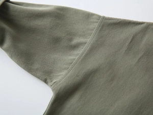 Détails des coutures et du tissu sergé résistant sur cette chemise garçon olive