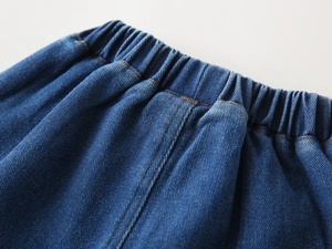 Close-up of boys denim jeans featuring a flexible elastic waistband and washed blue fabric