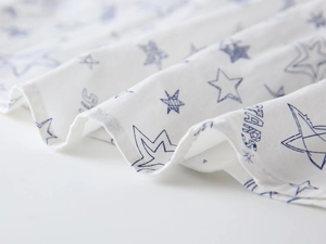 Close-up of white cotton fabric with blue star patterns and Stars lettering detail