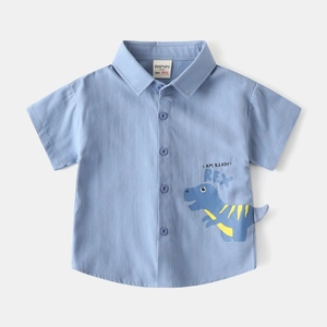 Détail de chemise bleue pour garçon avec motif dinosaure et texture en coton de haute qualité