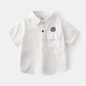 Close-up of white cotton boy's shirt featuring navy blue B embroidery and front pocket