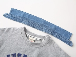 Gros plan détaillé d'un sweat en coton gris avec un col en jean bleu amovible stylé