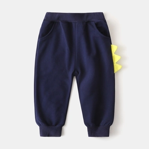 Détail d'un jogging bleu marine pour garçon avec pointes de dinosaure jaunes et bords-côtes