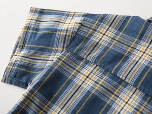 Gros plan d'une chemise à carreaux pour garçon montrant les coutures et le tissu en coton