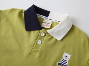Détail du polo pour enfants avec col contrasté et broderie d'ours sur la poitrine