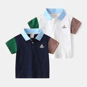 Détail de polo pour garçons en coton avec manches contrastées et broderie chien de surf