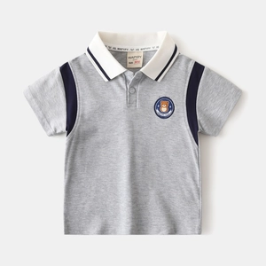 Detail of boys grey polo shirt featuring navy raglan sleeves and bear patch embroidery