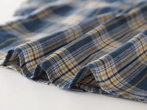 Gros plan sur la texture du tissu à carreaux bleu marine et jaune pour chemise garçon