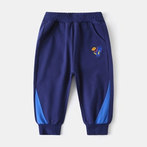 Détail de la broderie dinosaure et ourlet contrasté sur ce jogging en coton bleu marine