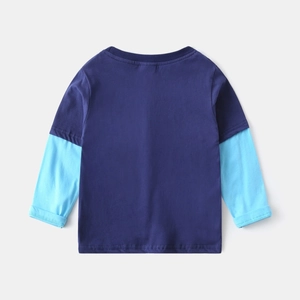 Détail des coutures de manches superposées bleu marine et ciel sur t-shirt enfant