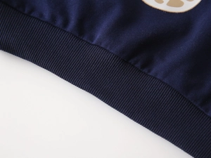 Détail des poignets côtelés bleu foncé et texture en coton du sweat-shirt pour enfants
