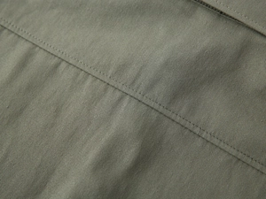 Vue détaillée du tissu sergé vert olive et de la finition couture à double surpiqûre