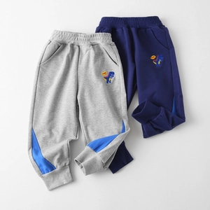 Détail du jogging garçon avec broderie dinosaure et empiècement contrasté bleu