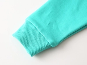 Détail du poignet côtelé sur sweat-shirt en coton vert menthe avec coutures soignées et nettes