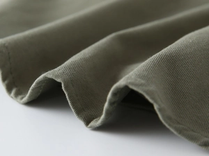Détail macro d'une chemise en sergé de coton olive pour garçon avec texture et coutures