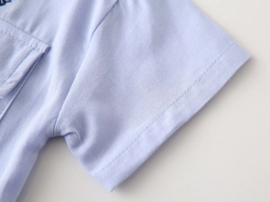 Detailed close-up of boy's light blue cotton shirt sleeve with neat double stitching