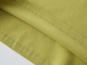 Gros plan sur la double couture et l'ourlet soigné de ce polo en coton pour garçons