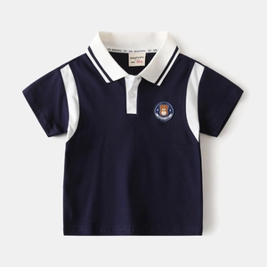 Close-up of navy blue polo shirt featuring white contrast collar and bear embroidery patch