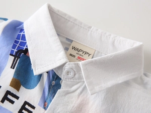 Gros plan du col de chemise pour garçon avec motifs géométriques et étiquette tissée
