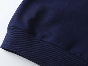 Detailed close-up of navy blue ribbed cuffs on boys' knit sweatshirt with clean stitching