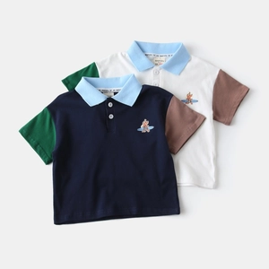 Détail d'un polo en coton pour garçon avec manches contrastées et broderie de chien mignon