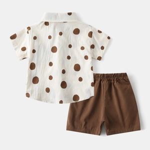 Detailed flat lay of boys beige polka dot shirt and brown elastic waist shorts set