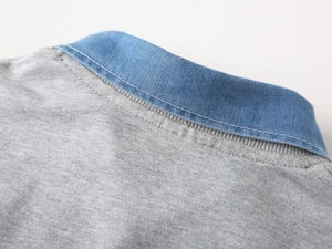 Détail d'un sweat gris pour enfant avec faux col en denim et coutures soignées