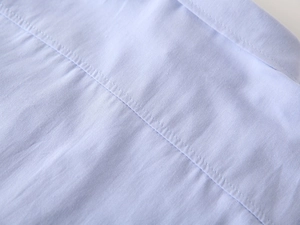 Macro shot of light blue cotton twill fabric with precision double-stitch sewing details