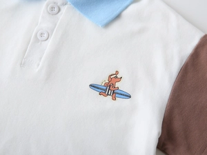 Détail d'un polo en coton piqué pour garçon avec broderie de chiot et col contrasté