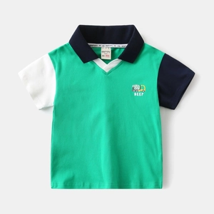 Detail of boys' color-block polo shirt with truck embroidery and premium cotton texture