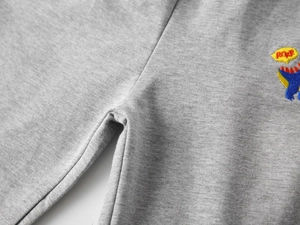 Détail du jogging gris pour enfant avec broderie dinosaure colorée et texte ROAR sur tissu