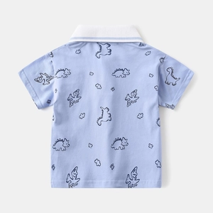 Detail of light blue kids polo shirt featuring cute dinosaur and cloud cartoon prints