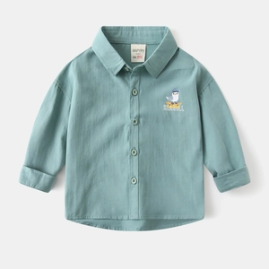 Close-up of seagull embroidery on mint green kids shirt with brand and size label