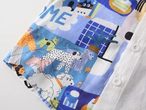 Détail du tissu d'une chemise bleu clair imprimée avec boutons blancs et motifs de dessins