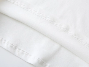 Détail de la couture à double aiguille sur le tissu en coton blanc de qualité supérieure