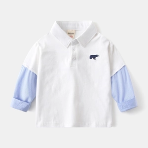 Detail of kids polo shirt with blue bear embroidery and striped patchwork sleeves