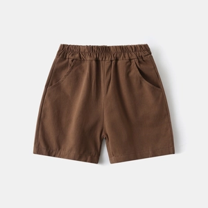 Close-up of boys brown cotton shorts featuring elastic waist and functional side pockets