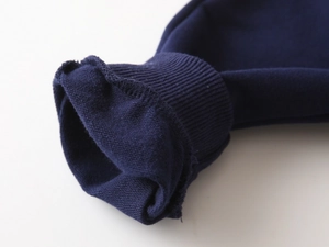 Détail macro des poignets en coton côtelé bleu marine sur ce sweat-shirt pour enfants