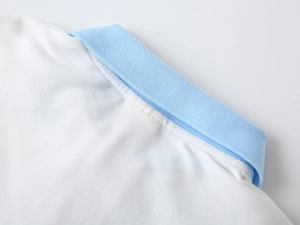 Détail du polo pour bébé avec col bleu clair et tissu en coton piqué blanc de qualité