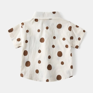 Detailed texture of cotton linen boys' shirt with stylish brown polka dot print