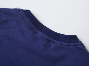 Détail du col rond et des coutures doubles sur le t-shirt en coton pour enfants