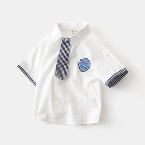 Close-up of boys white short sleeve shirt with space embroidery and checkered tie detail