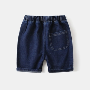 Détail d'un short en jean bleu foncé avec taille élastique et ourlet replié pour enfant