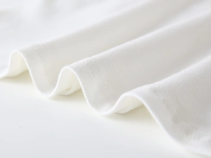 Vue détaillée de la maille blanche avec double piqûre plate sur l'ourlet du polo