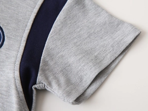 Macro shot of breathable grey pique fabric sleeve with navy trim and embroidery detail