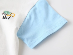 Close-up of children's white and blue polo shirt with yellow truck embroidery and text
