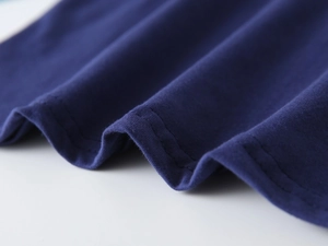 Détail du tissu en coton bleu marine avec double couture soignée et texture douce de t-shirt
