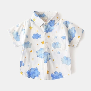 Detailed macro shot of white kids cotton shirt with blue clouds and yellow stars print